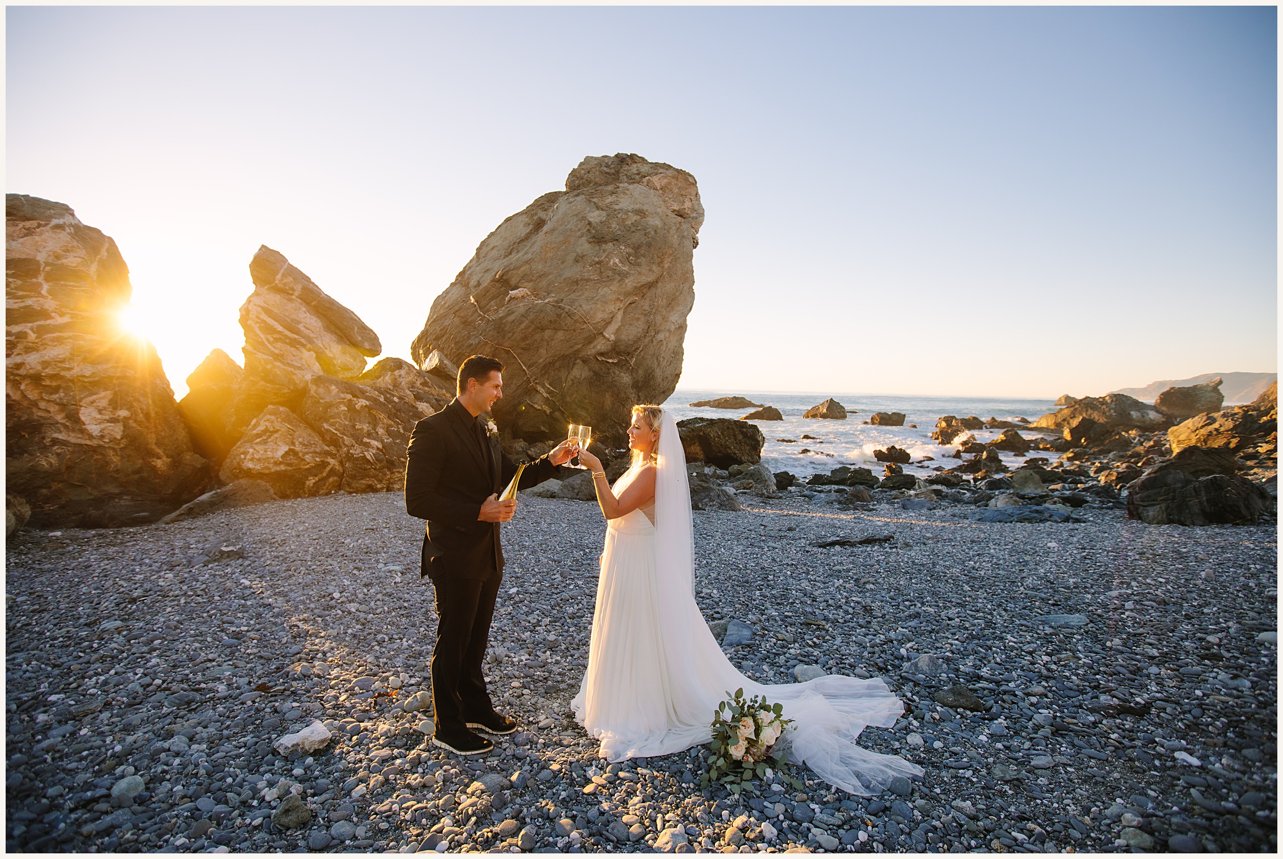 Photo of bride and groom on Catalina Island beach cheering champagne