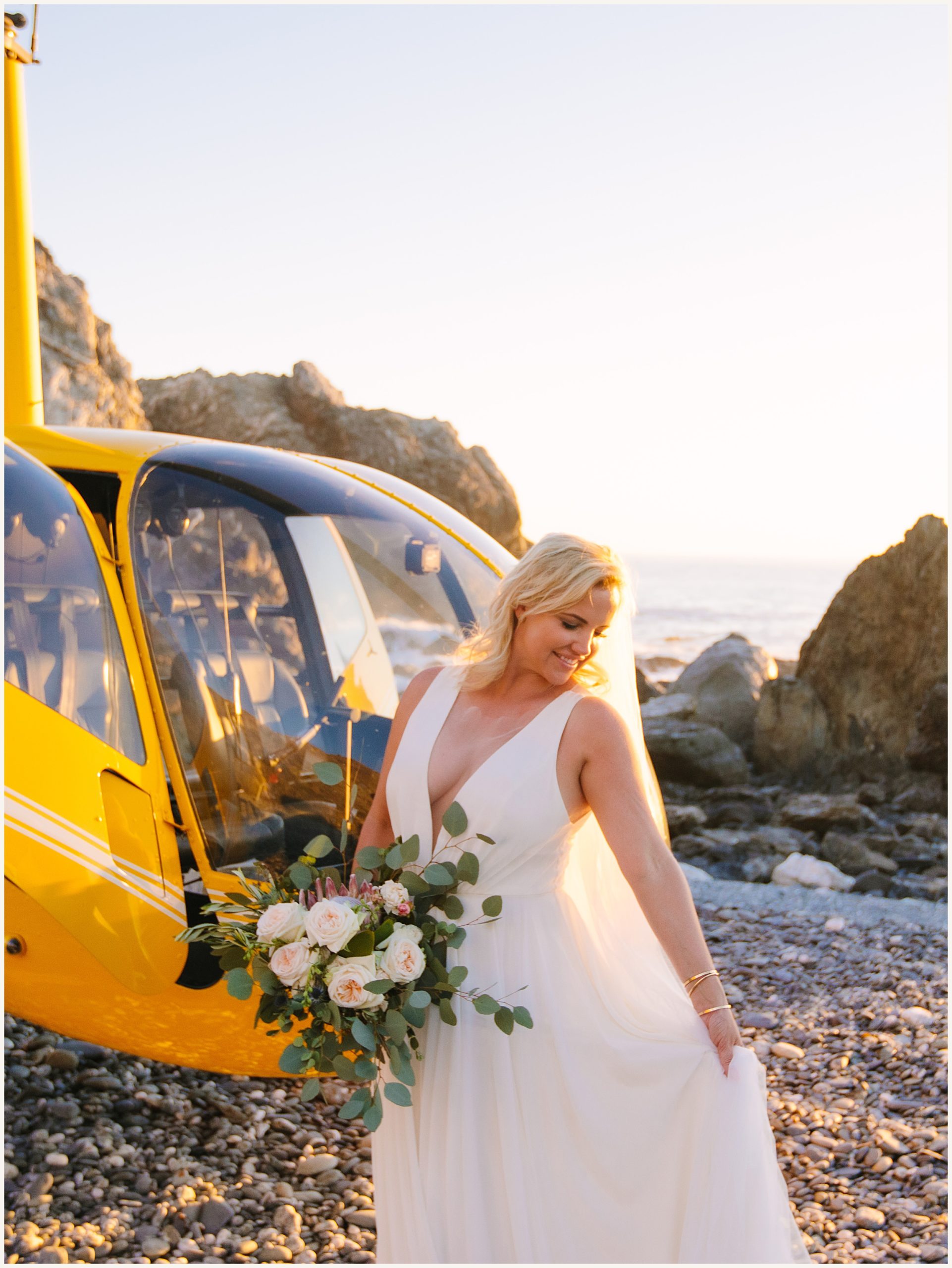 Photo of bride in stunning A-line white elopement dress in front of yellow helicopter