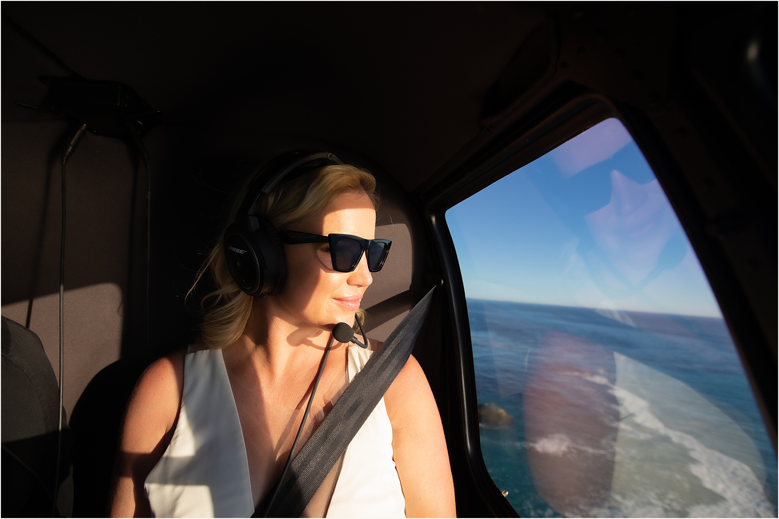 photo of a bride looking out of a helicopter with sunglasses on