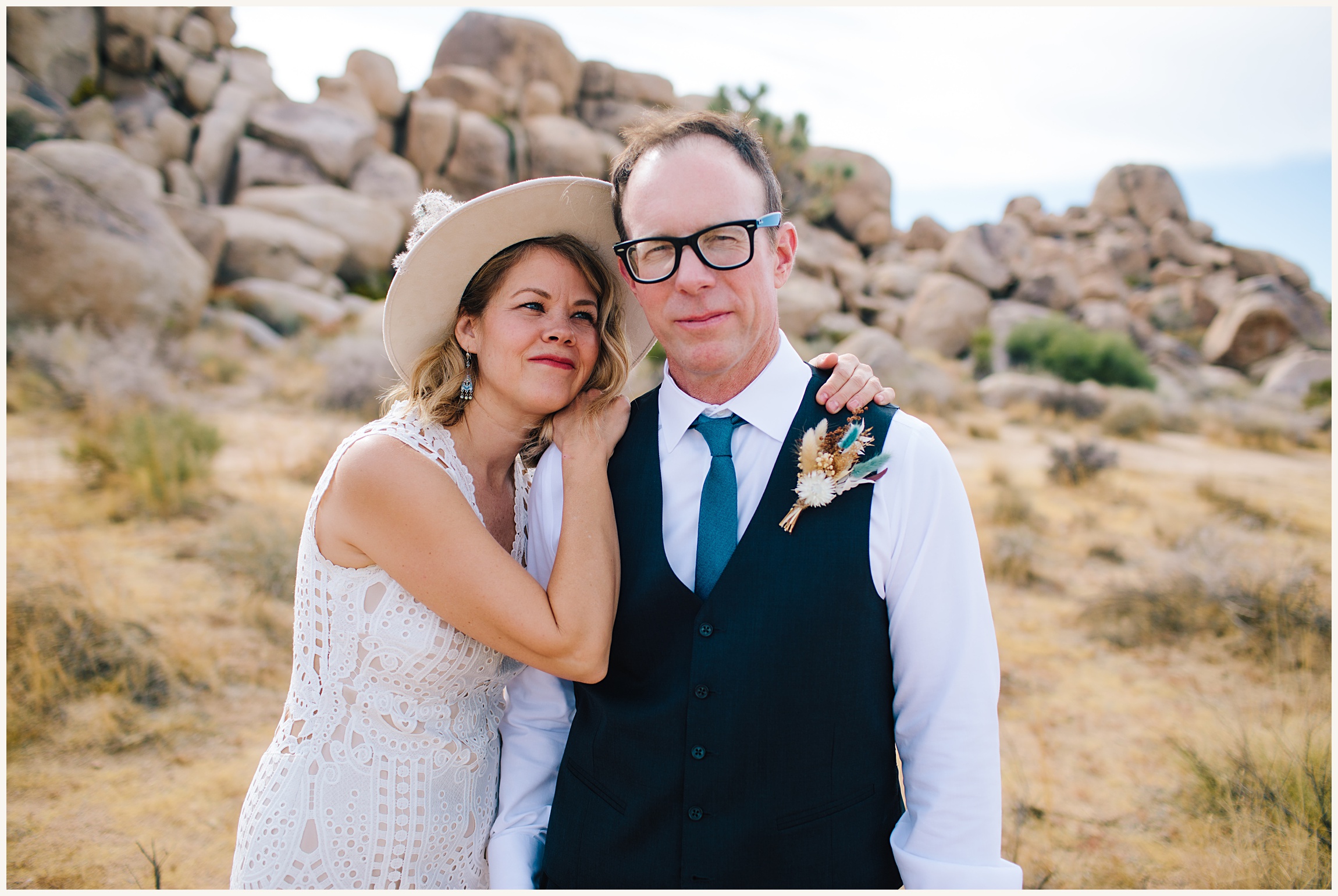 Photo of bride wearing a boho elegant white lace A-line elopement dress and groom wearing a black wedding vest and white button up