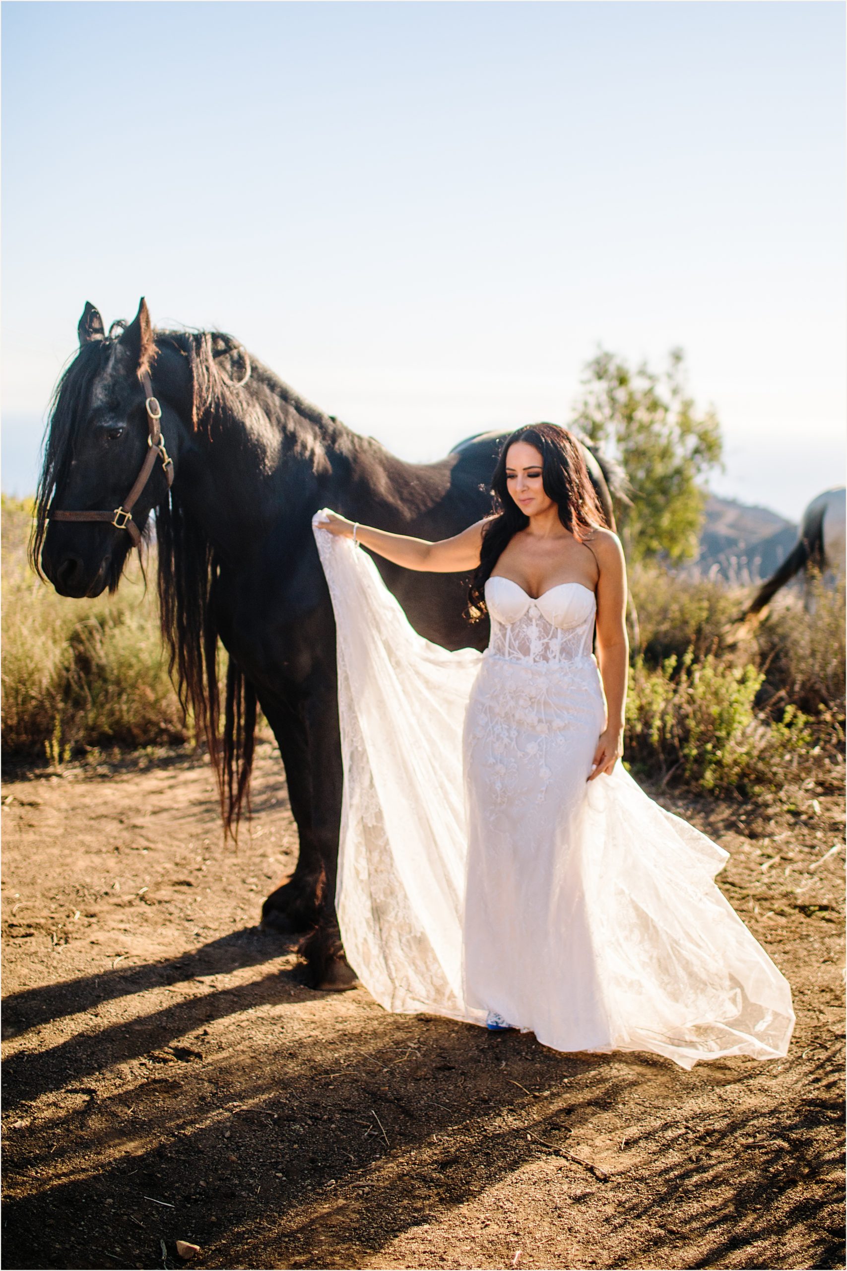 Photo of bride posing next to a beautiful brown horse in a strapless lace mermaid elopement dress