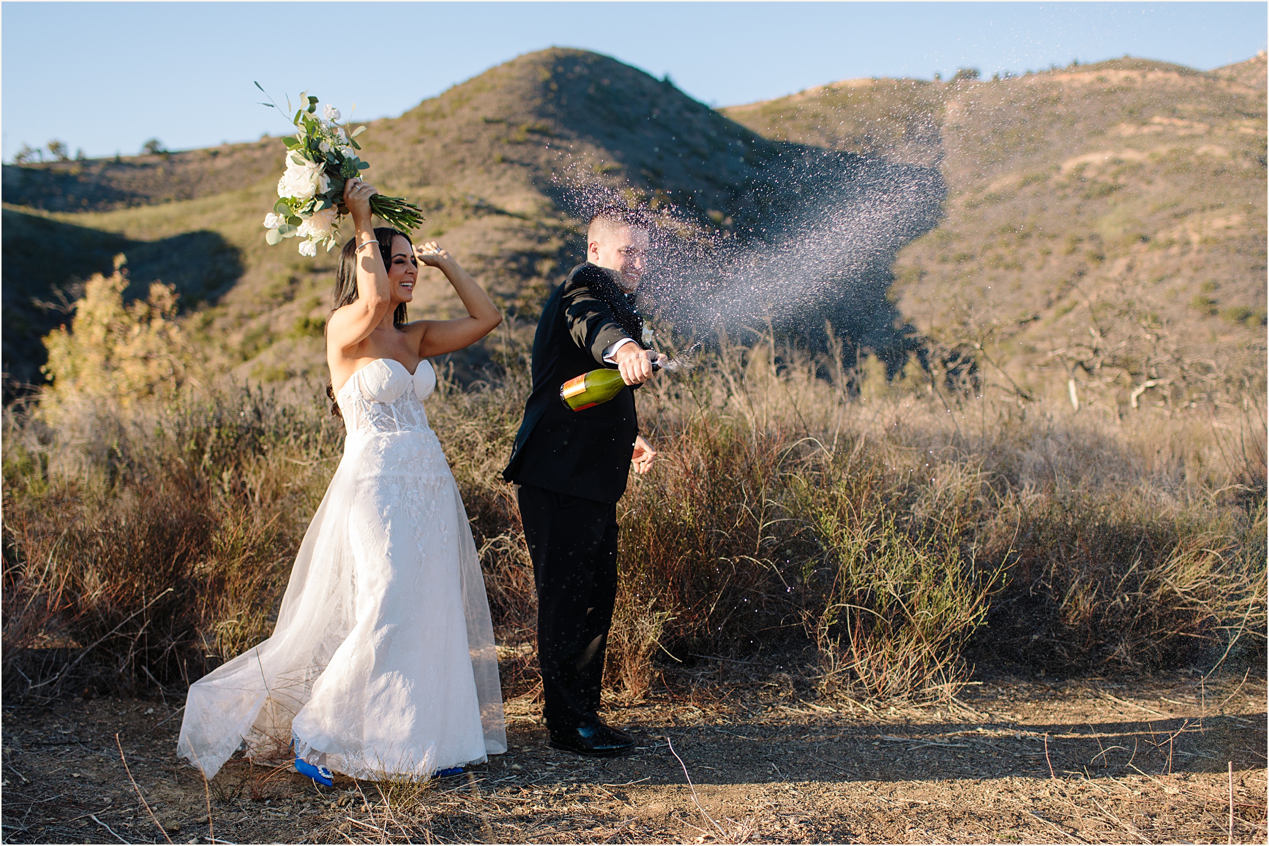 Photo of bride and groom popping champagne