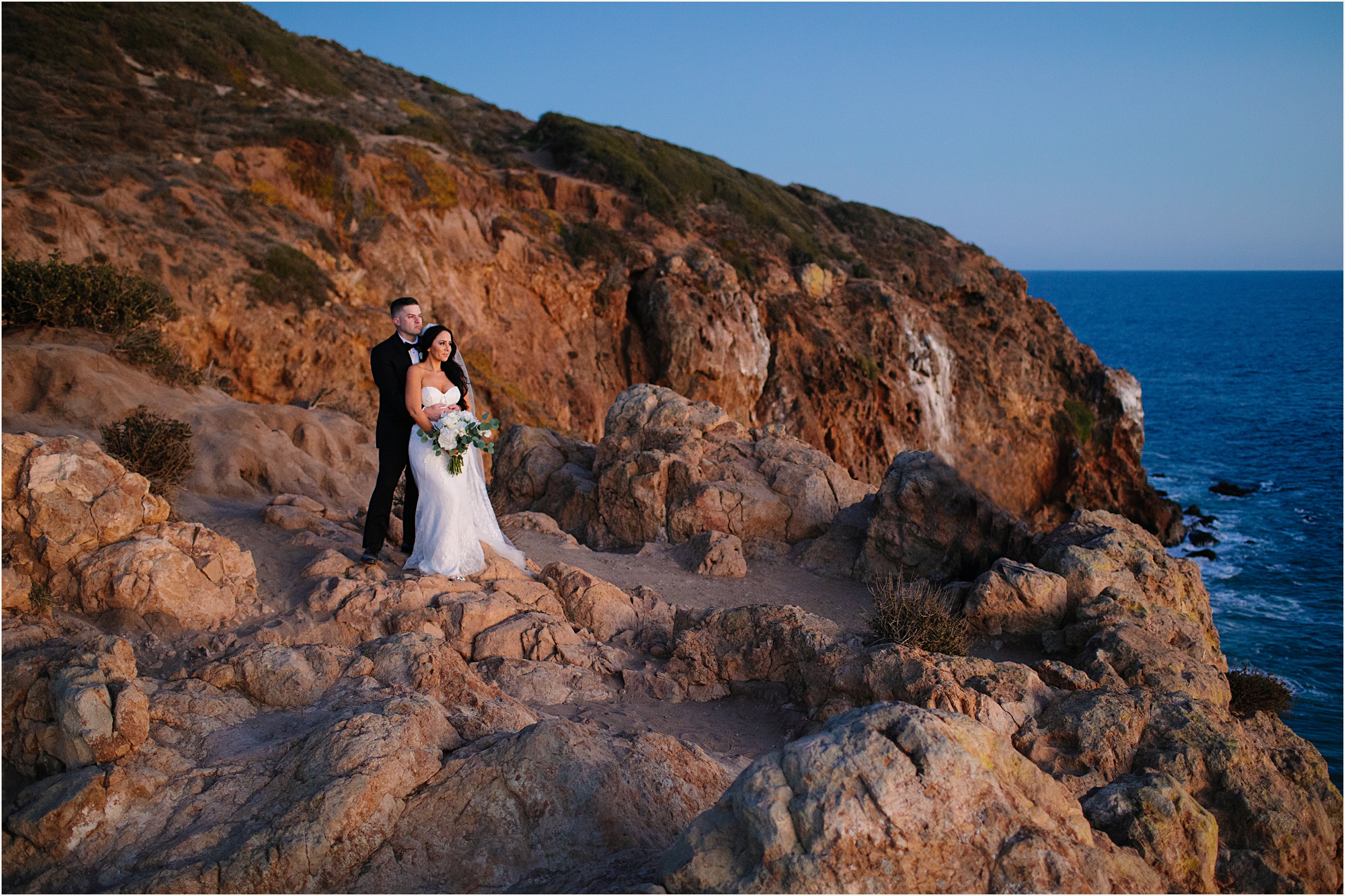 Photo of bride and groom on cliffside view during their Malibu beach elopement