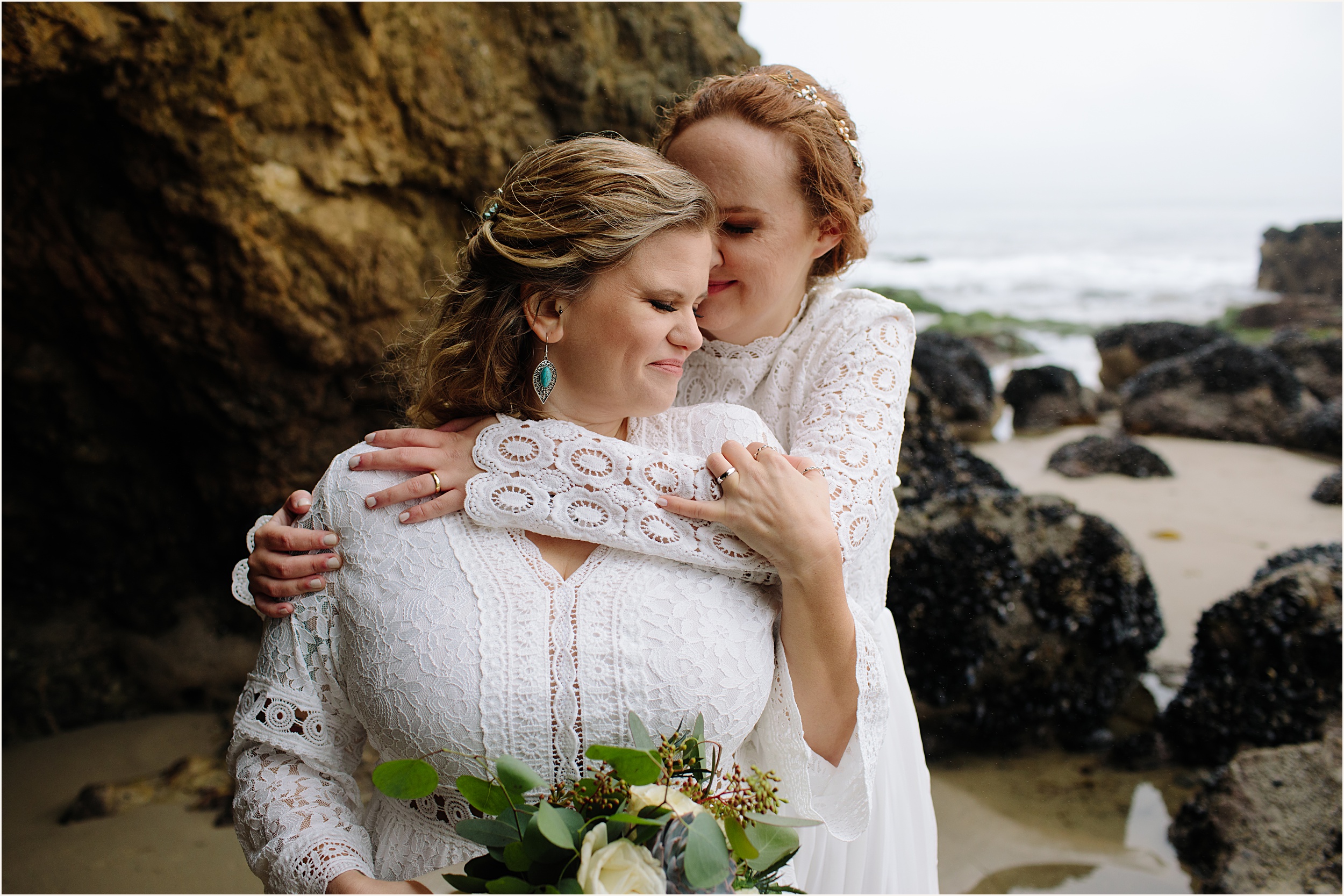 Photo of brides in stunning white lace elopement dresses at El Matador beach cave